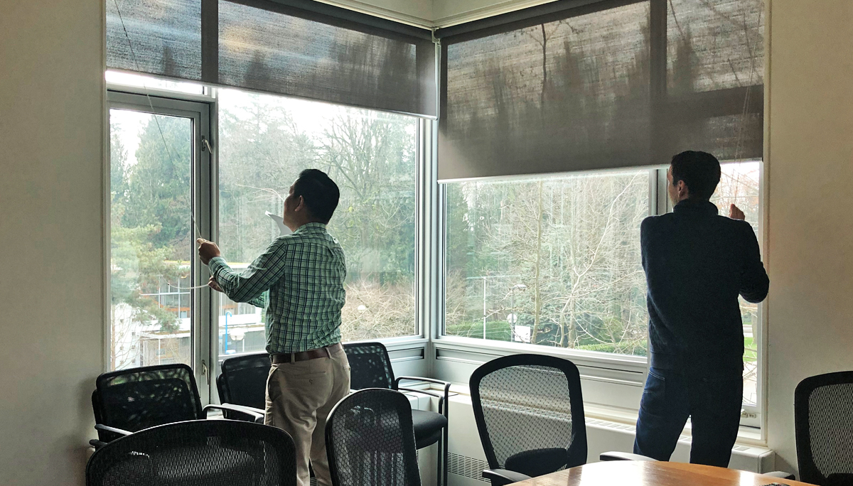 Staff from school of journalism take down window shades